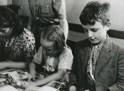 876623 Portret van enkele kinderen die tijdschriften 'De Stad Gods' aan het vouwen zijn voor verdere distributie, in ...